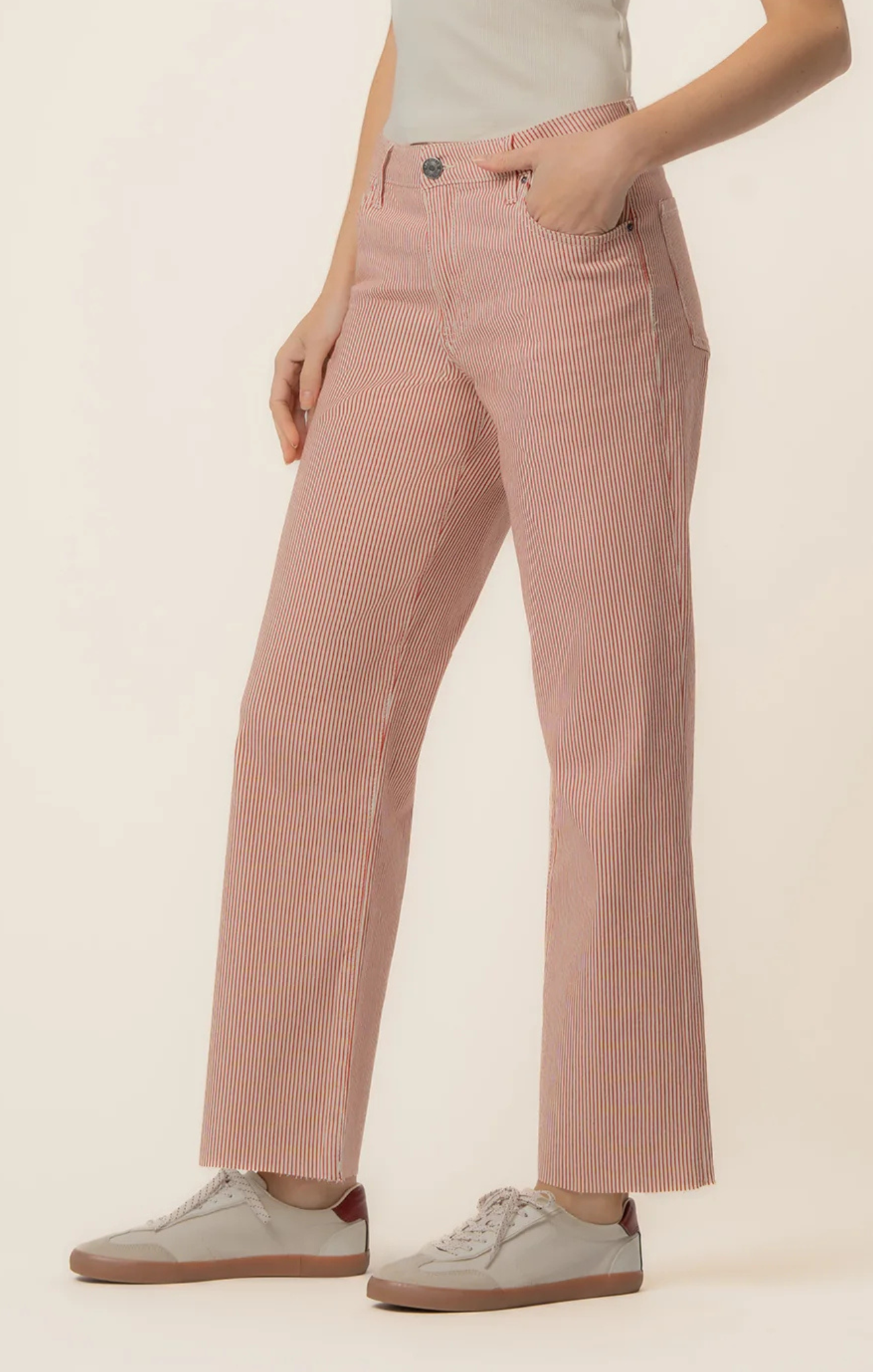 Person wearing pink striped pants on a beige background