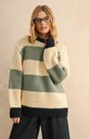 Woman wearing a striped sweater with green and beige colors on a beige background