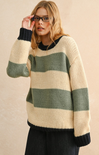 Woman wearing a striped sweater with green and beige colors on a beige background