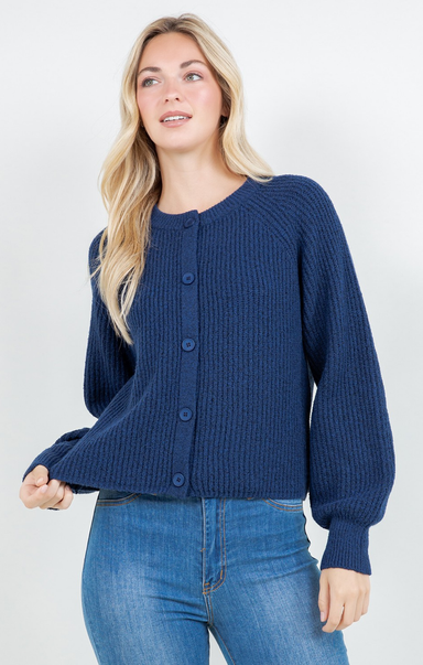 Woman wearing a blue knitted cardigan and jeans on a white background