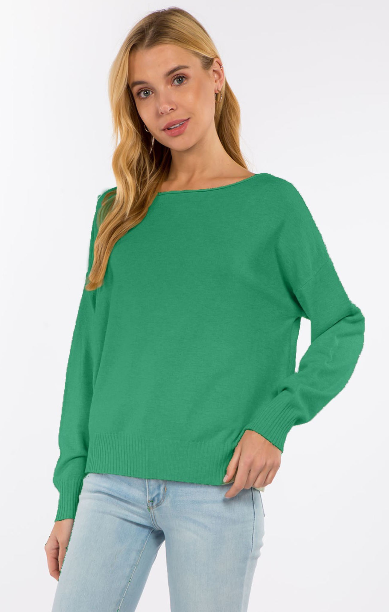 Woman wearing a green sweater and light blue jeans on a white background