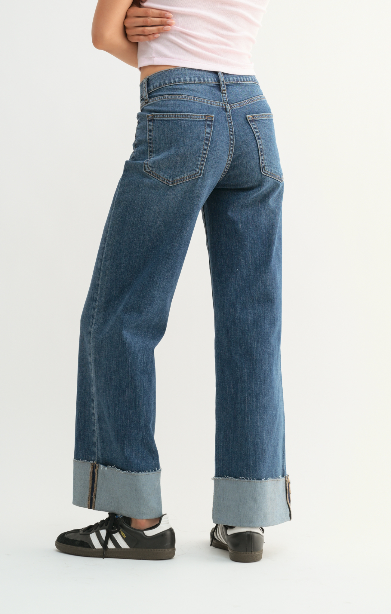 Person wearing blue jeans with a white background