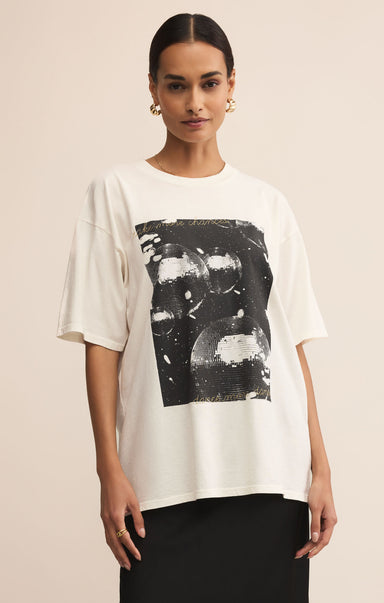 Woman wearing a white t-shirt with black abstract design on a beige background