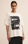 Woman wearing a white t-shirt with black abstract design on a beige background