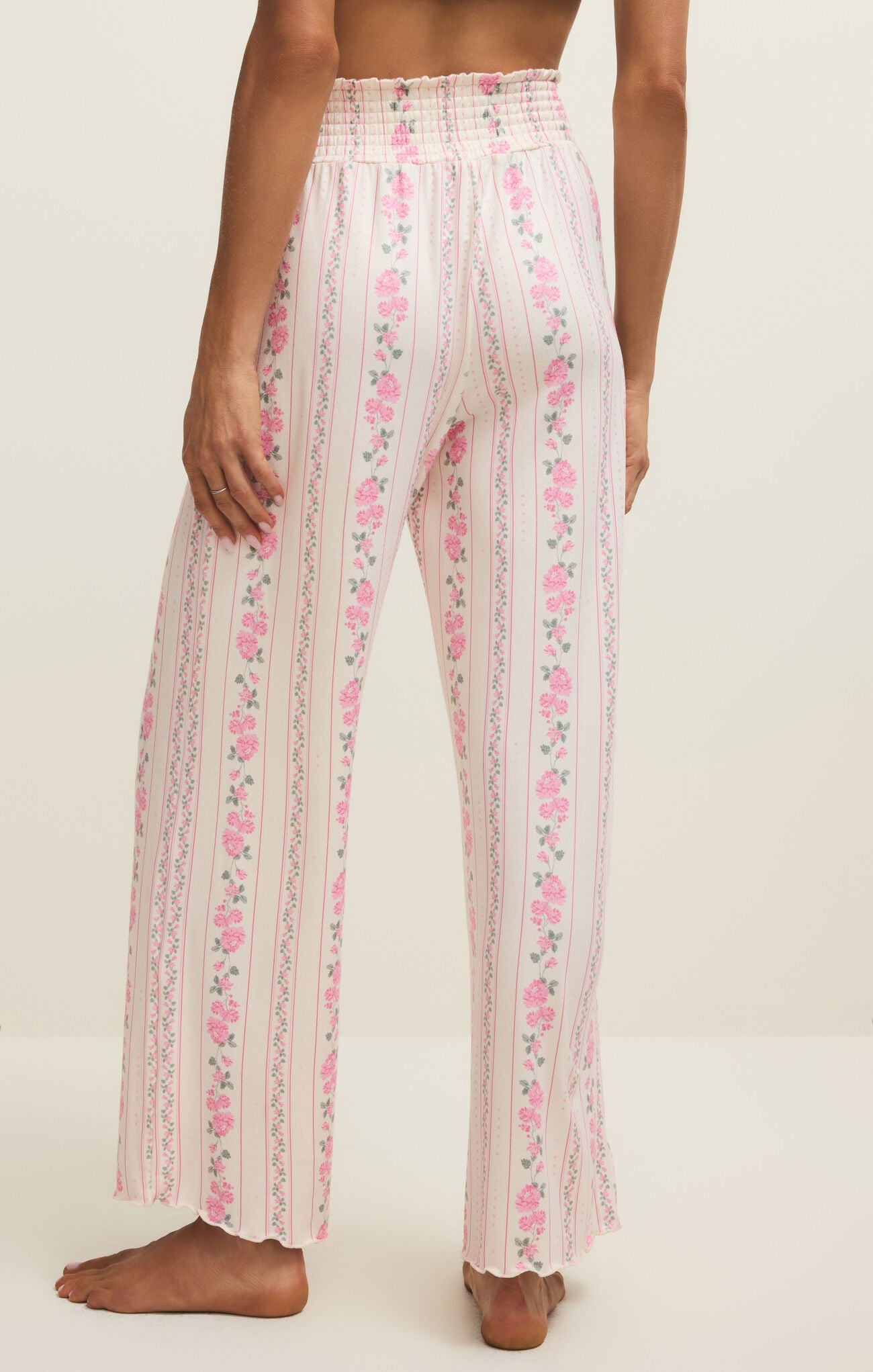 Floral patterned pants worn by a person on a plain background
