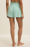Person wearing light green shorts on a plain background
