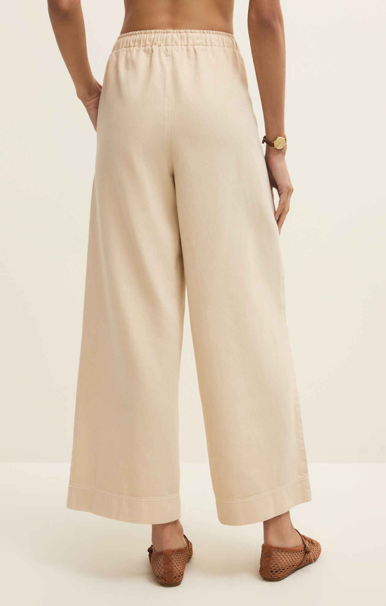 Beige wide-leg pants worn by a person on a plain background