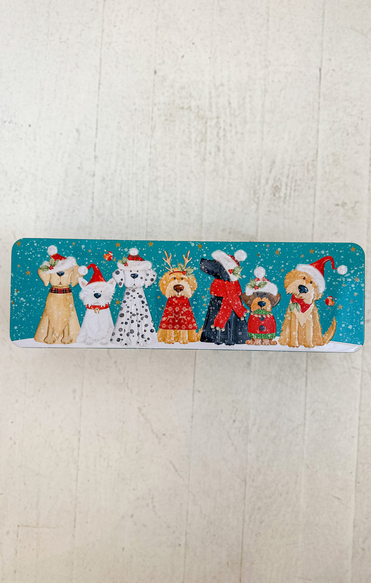 Decorative mat with cartoon dogs wearing Christmas hats and scarves on a light wooden floor.