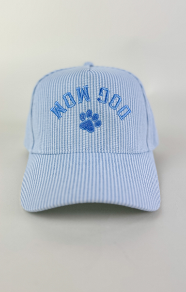 Light blue and white striped baseball cap with “Dog Mom” embroidered in blue lettering above a blue paw print on the front.