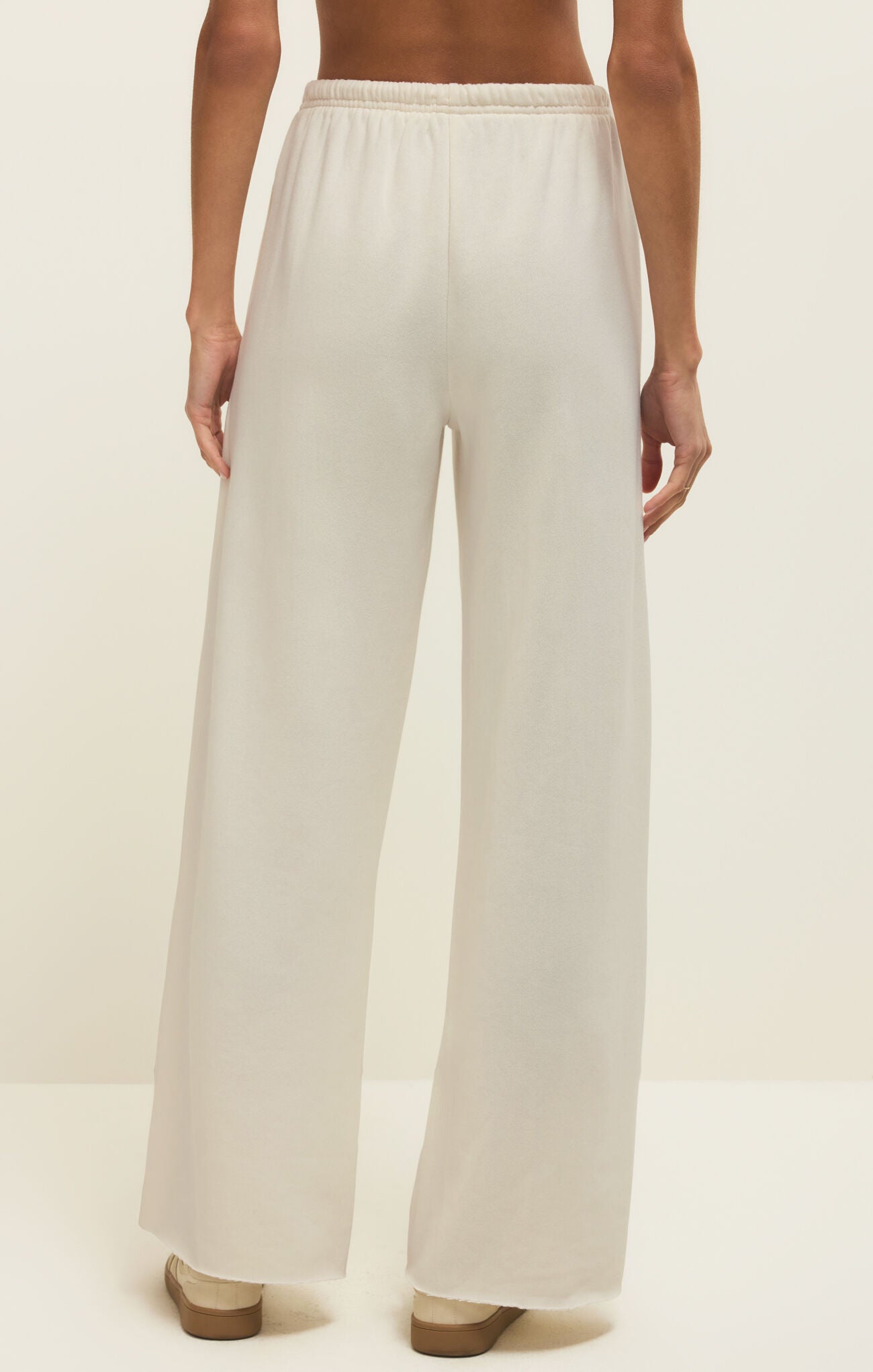 White wide-leg pants worn by a person on a plain background