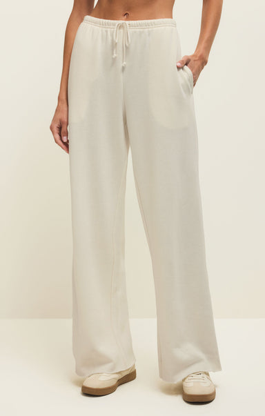 Person wearing white wide-leg pants on a plain background