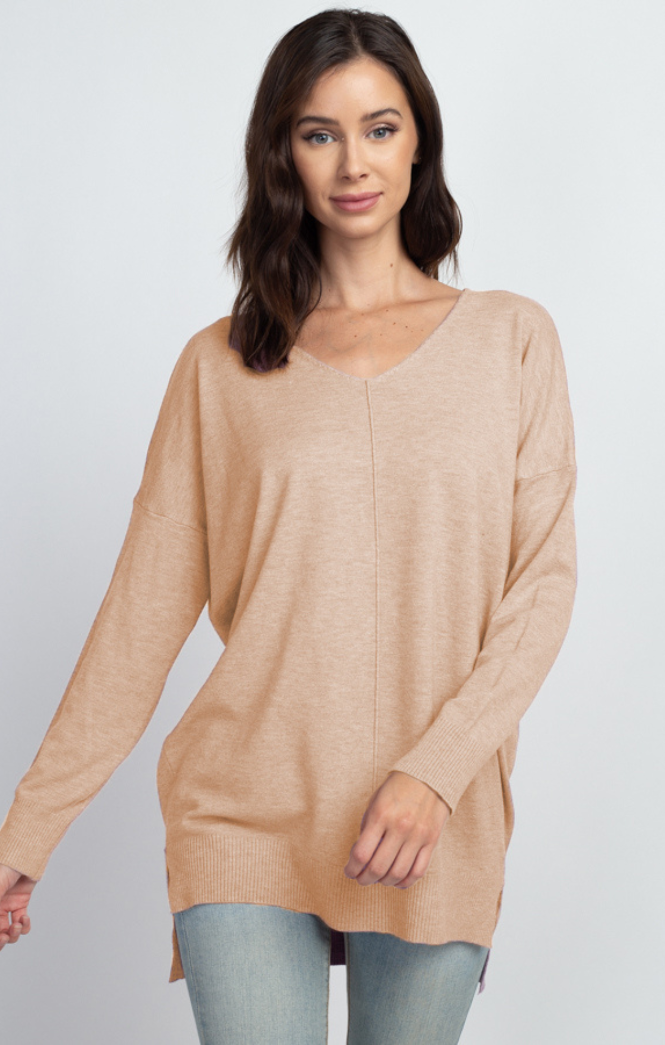 Woman wearing a beige sweater on a white background