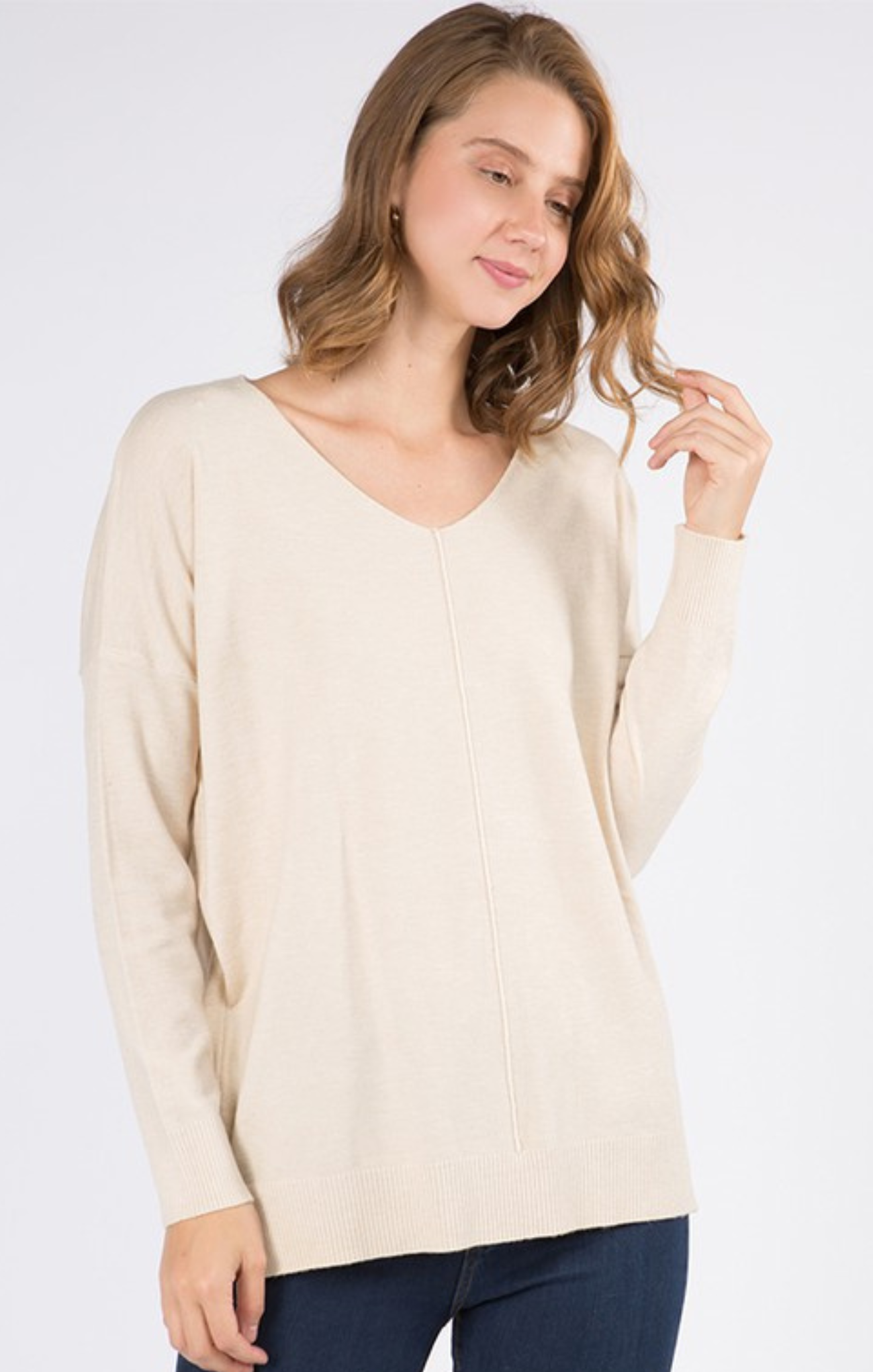 Woman wearing a beige sweater against a white background