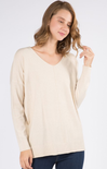Woman wearing a beige sweater against a white background