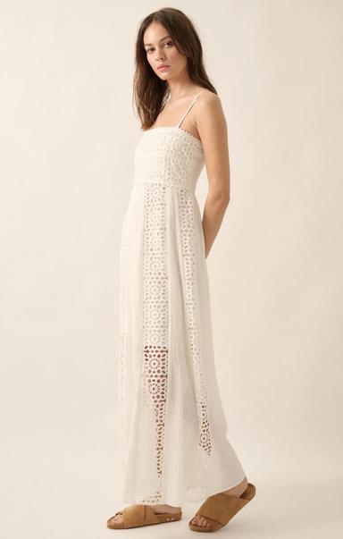 Woman wearing a white lace dress on a plain background