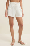 White shorts worn by a person on a beige background