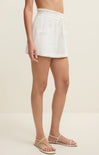 Person wearing a white skirt on a beige background