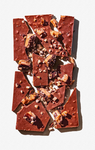 Chocolate bark with nuts and cranberries on a white background