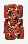 Chocolate bark with nuts and cranberries on a white background