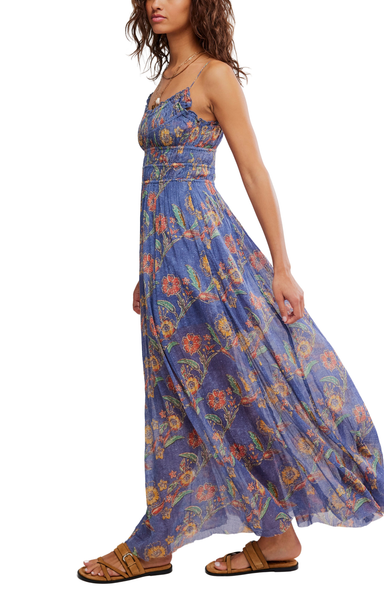 Woman wearing a blue floral maxi dress on a white background