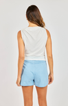 woman wearing white cowl neck tank with blue shorts on white background