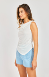 woman wearing white cowl neck tank with blue shorts on white background