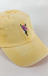 Butter yellow baseball cap with a small embroidered pink and purple flower bouquet centered on the front.