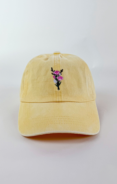 Butter yellow baseball cap with a small embroidered pink and purple flower bouquet centered on the front.