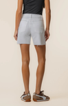 Person wearing light gray shorts on a beige background