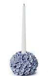 Decorative candle holder with blue floral design holding a white candle on a white background