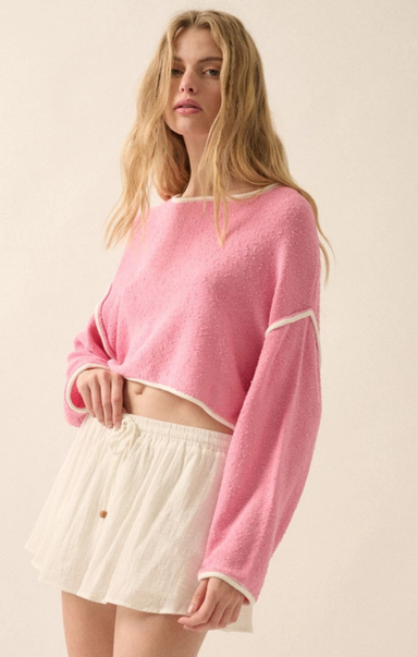 Woman wearing a pink sweater and white skirt on a beige background