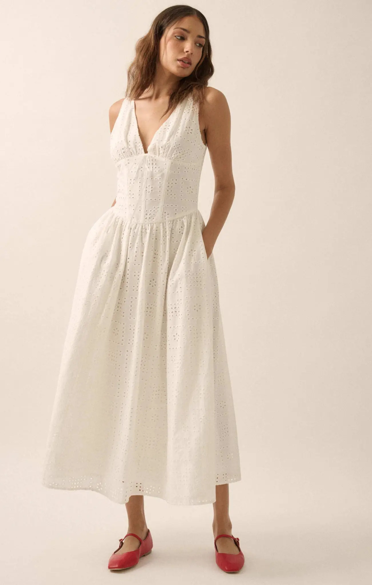 Woman wearing a white dress with a plain background