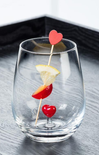 clear glass with heart in the middle with lemon and cherry on stick poking out on grey surface
