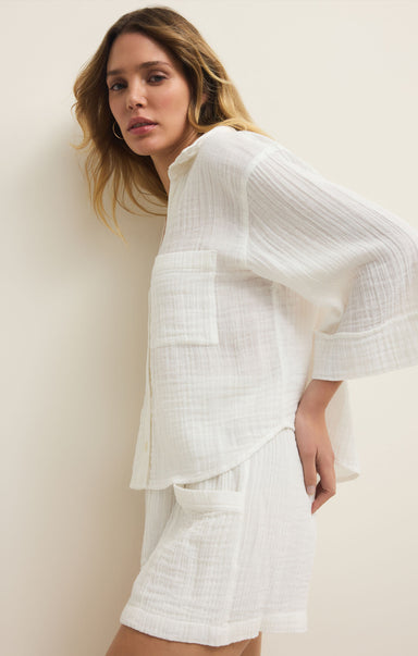 Woman wearing a white outfit against a plain background