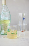 Decorative glass bottles with fish designs on a white surface