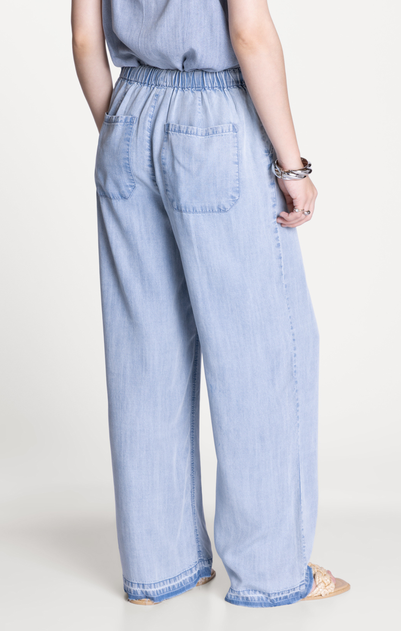 Light blue denim pants worn by a person on a white background