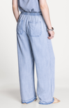 Light blue denim pants worn by a person on a white background