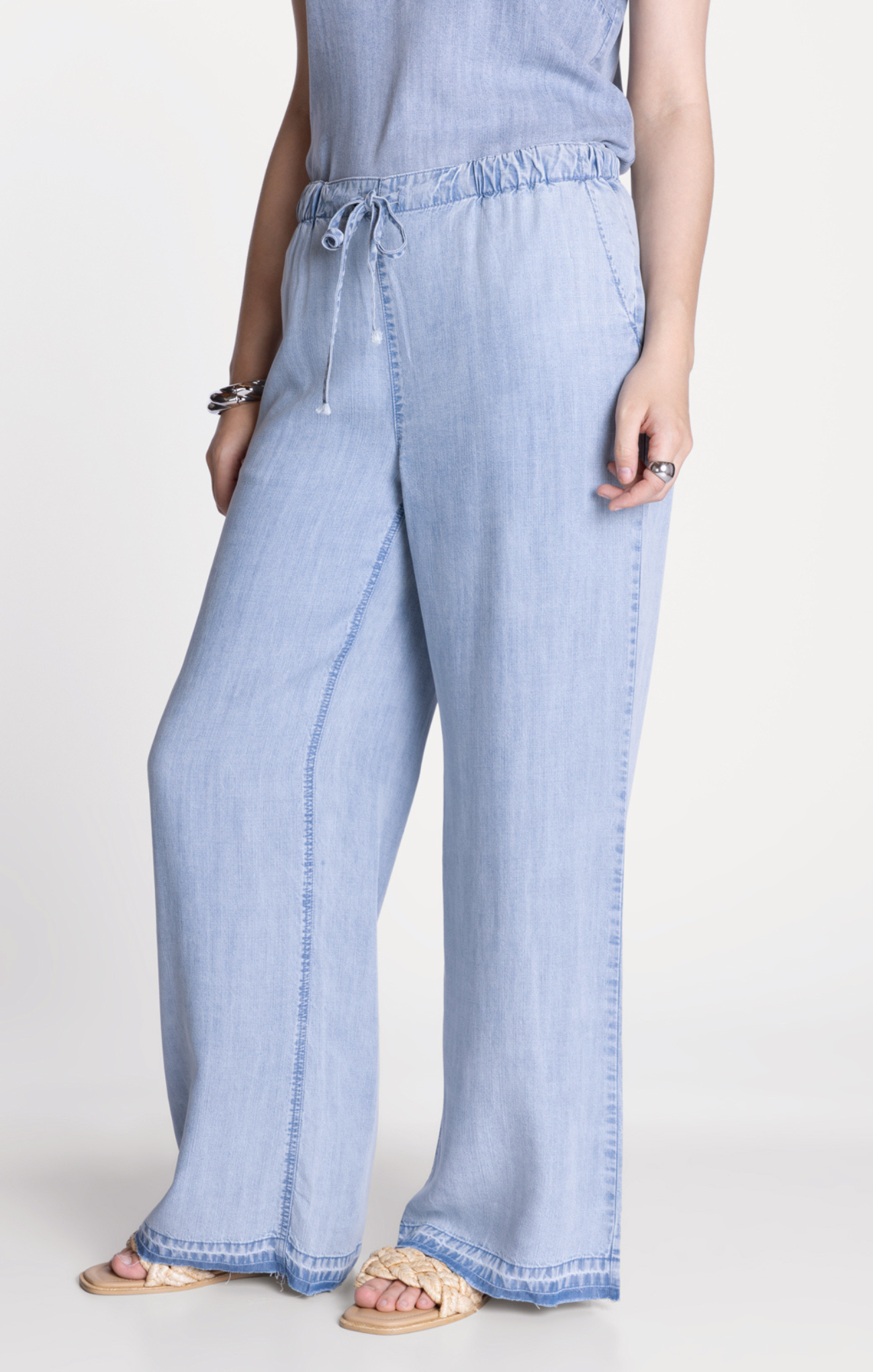 Light blue denim pants worn by a person on a white background