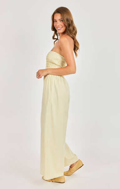 Woman wearing a strapless light-colored dress on a white background