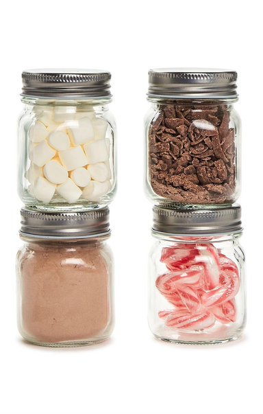 Four glass jars with metal lids containing different items on a white background