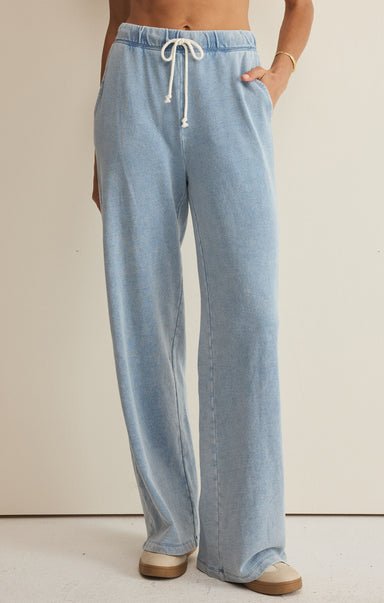 Light blue denim pants with a drawstring on a beige background