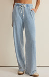 Light blue denim pants with a drawstring on a beige background