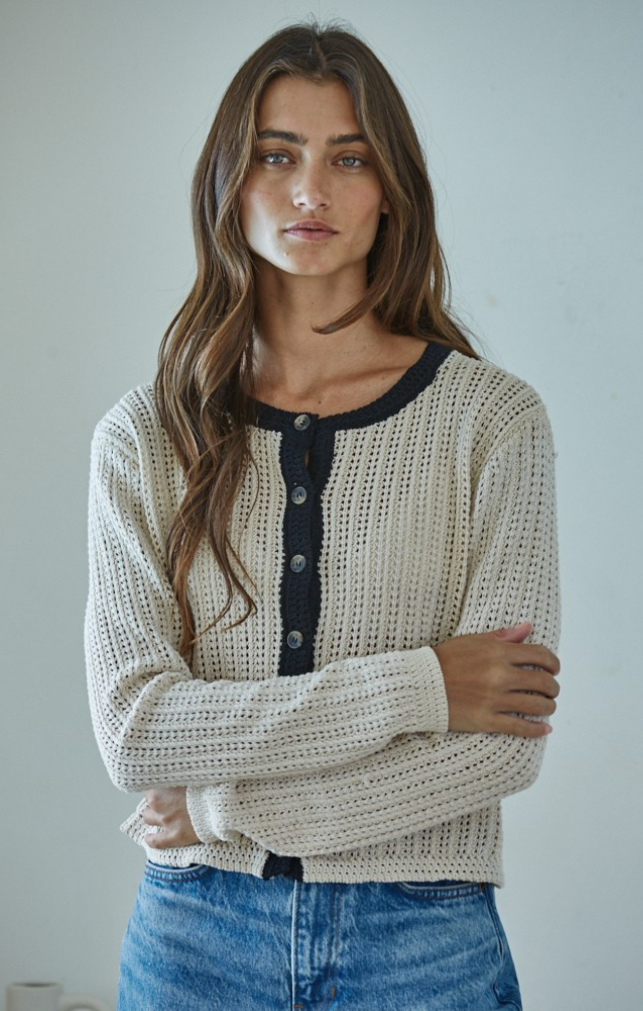 Woman wearing a textured cardigan with a plain background