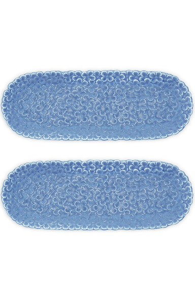 Two blue oval placemats with a floral pattern on a white background