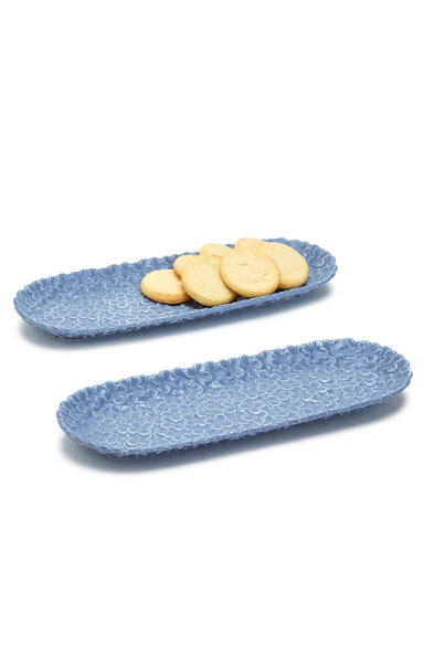 Two blue ceramic trays with cookies on a white background