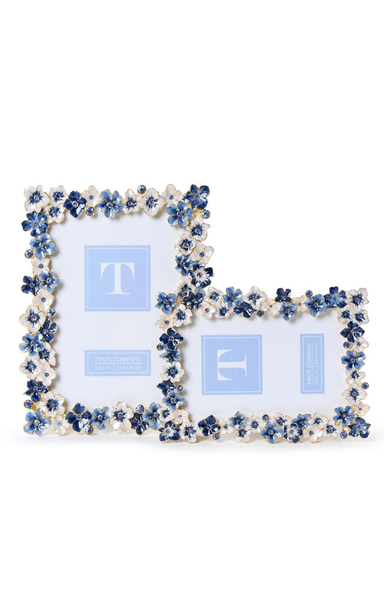 Decorative photo frame with blue floral embellishments on a white background