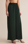 Dark green wide-leg pants worn by a person on a beige background