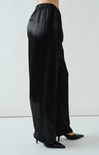 Black wide-leg pants worn by a person on a white background