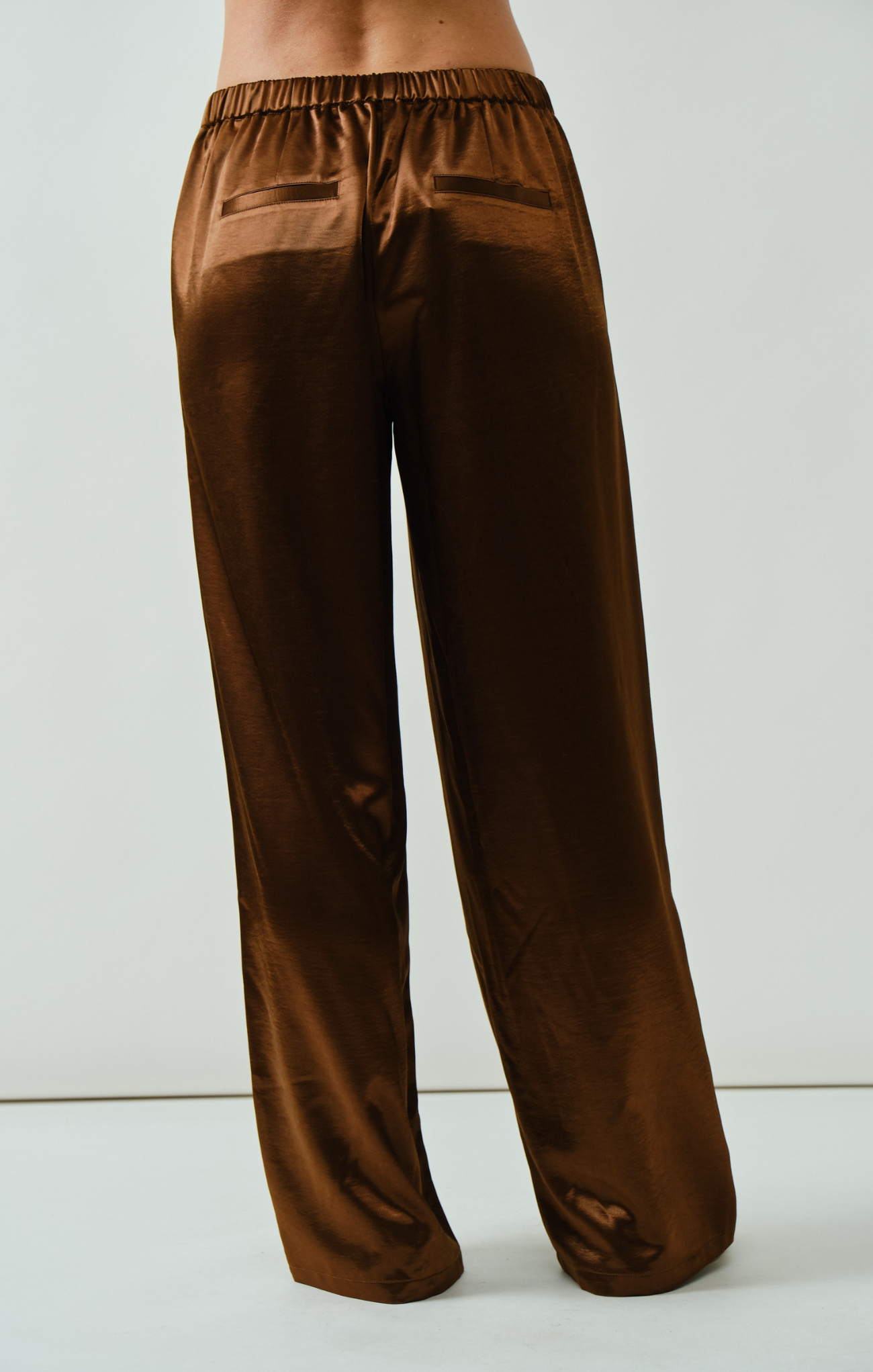 Brown satin pants on a white background