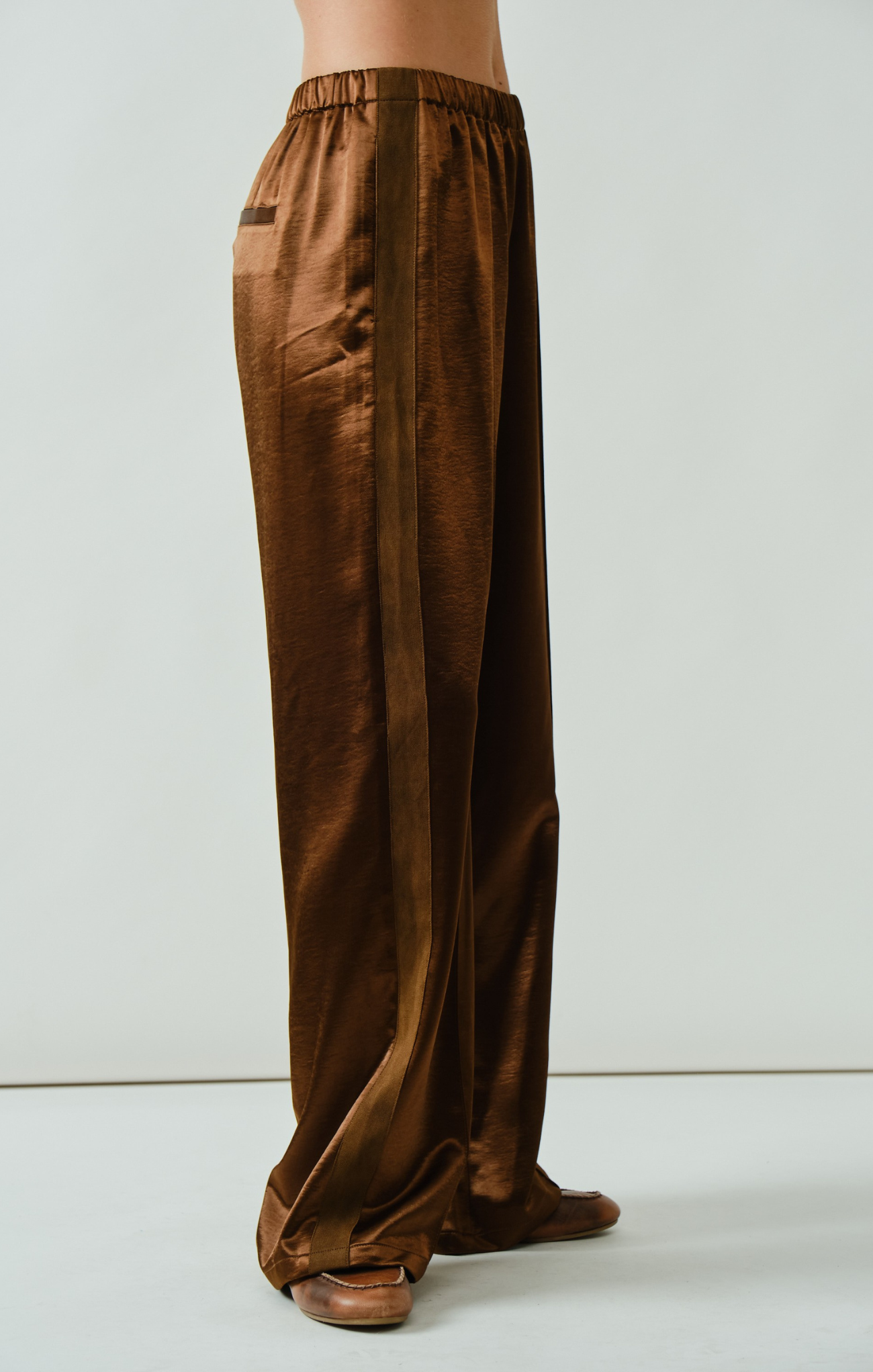 Brown wide-leg pants worn by a person on a white background